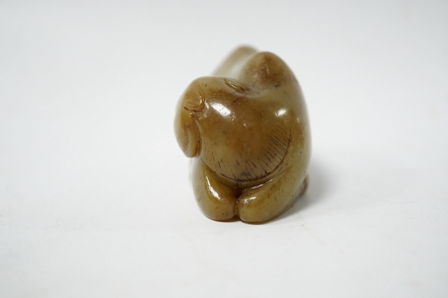 A Chinese carved jade figure of a recumbent Bactrian camel, 7.5cm long. Condition - good